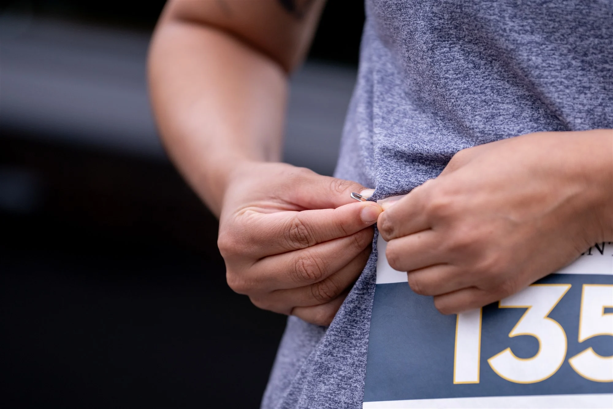 Läuferin steckt sich die Startnummer ans Shirt
